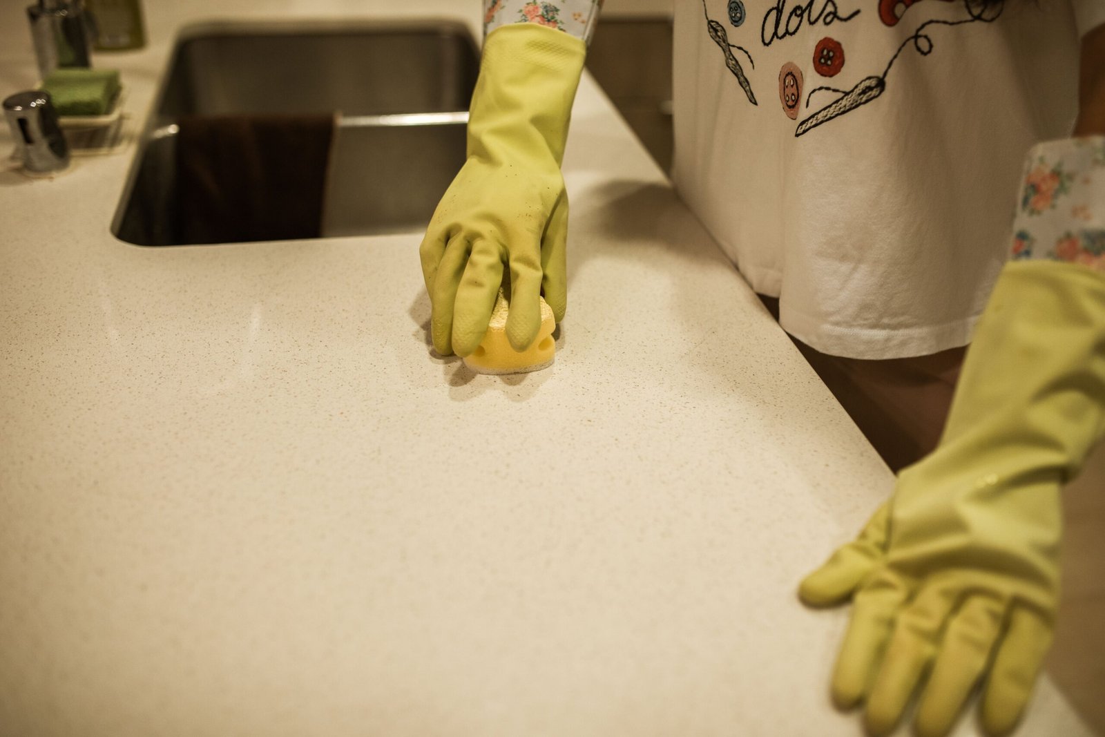 Cleaner wiping down a kitchen benchtop